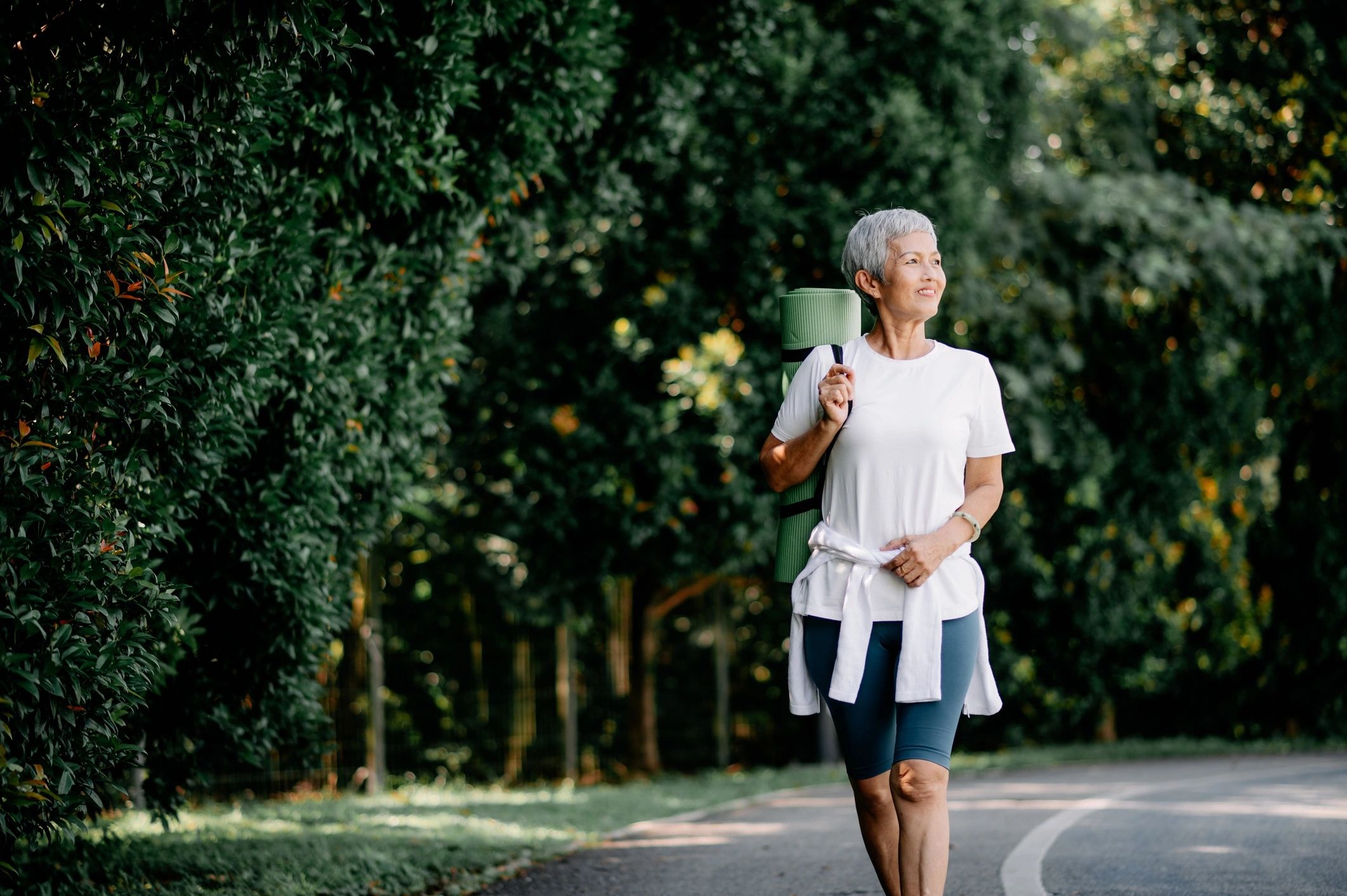 Woman walking outdoors in warm natural light — Age Well healthy aging support at Elitarc